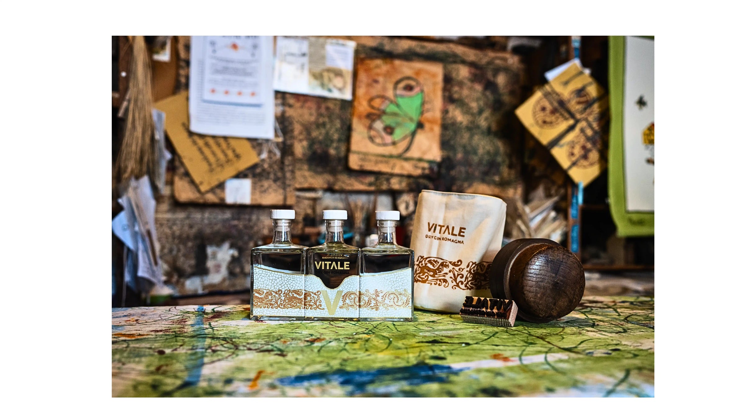 Bottiglie di Gin Vitale esposte all’interno della Stamperia Pascucci, immerse in un contesto di arte e tradizione romagnola, tra tele stampate a mano e strumenti artigianali.